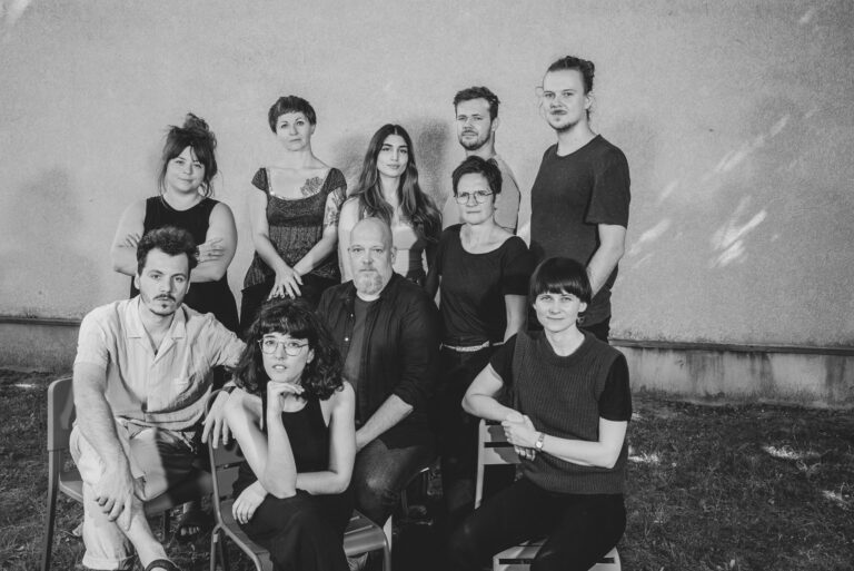 Schwarz-weiß-Foto: Eine Gruppe von zehn Menschen, vier Männer und sechs Frauen. Gruppenfoto, alle schauen in die Kamera.